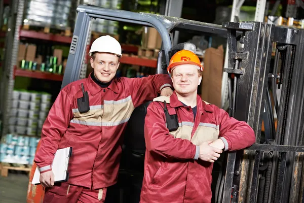 Warehouse workers in front of forklift — Stock Photo, Image