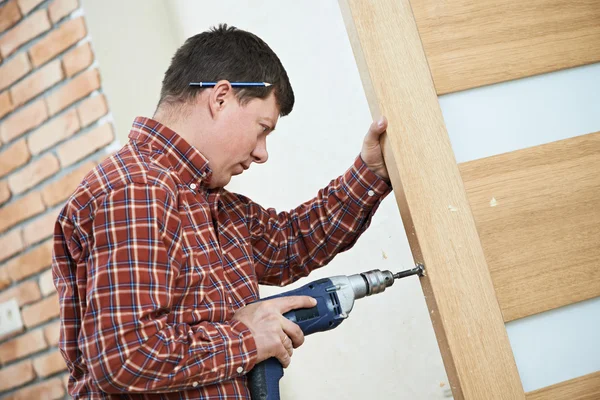 Carpenter at door lock installation — Stock Photo, Image