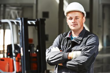 forklift önünde depo işçisi