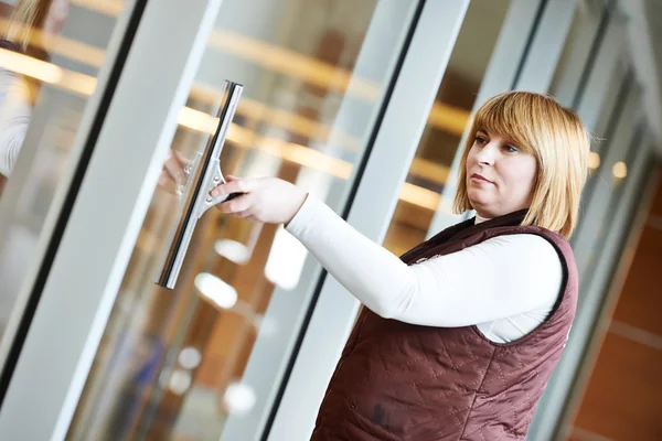 Vrouw werknemer schoonmaak binnen venster — Stockfoto