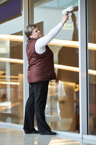 Kvinna arbetstagare rengöring inomhus fönster — Stockfoto