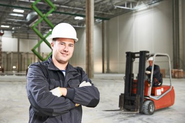 forklift önünde depo işçisi