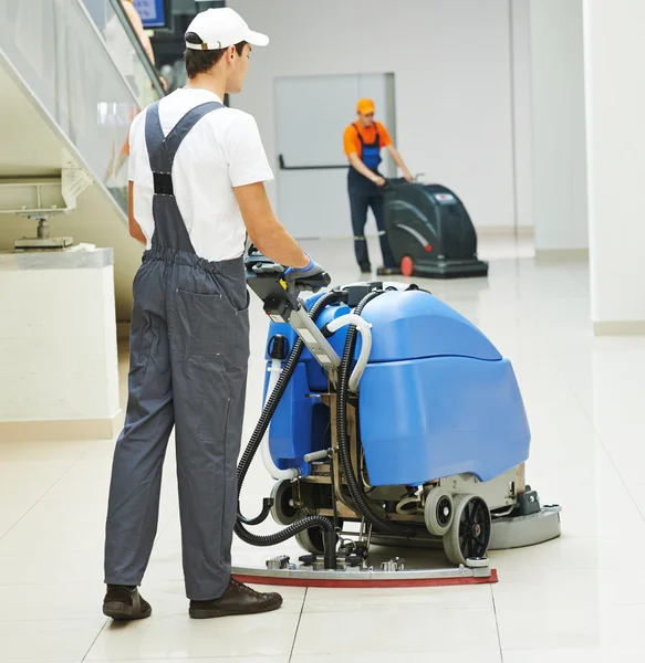 Male worker cleaning business hall — Stock Photo, Image