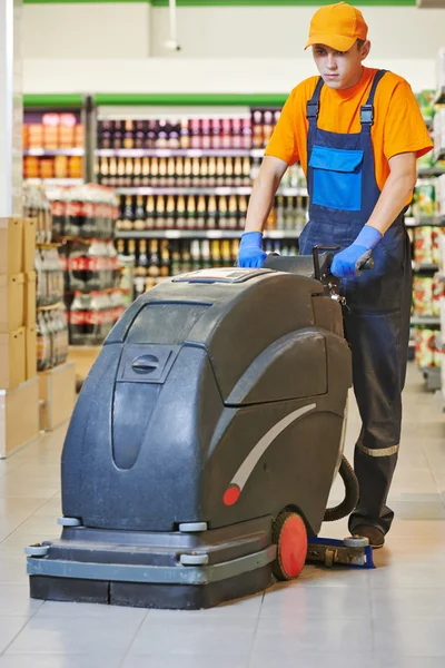 Worker cleaning store floor with machine — Stock Photo, Image