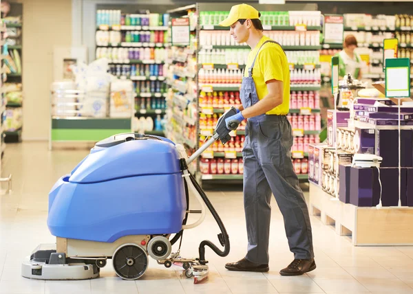 Werknemer schoonmaken winkelvloer met machine — Stockfoto