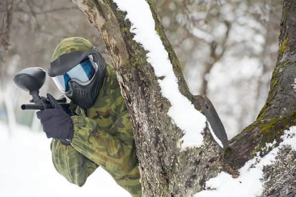 Пейнтболист с маркером зимой на открытом воздухе — стоковое фото