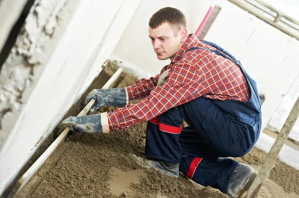 Plasterer concrete worker at floor work — Stock Photo, Image