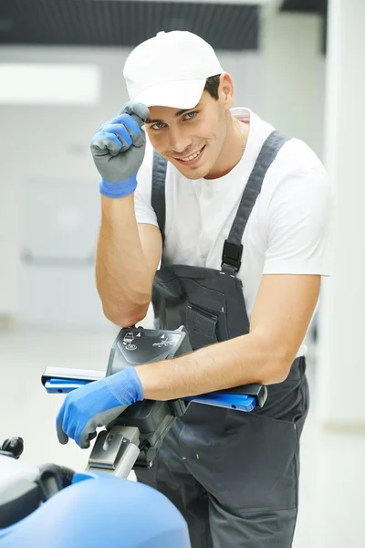 Trabalhador masculino limpeza salão de negócios — Fotografia de Stock
