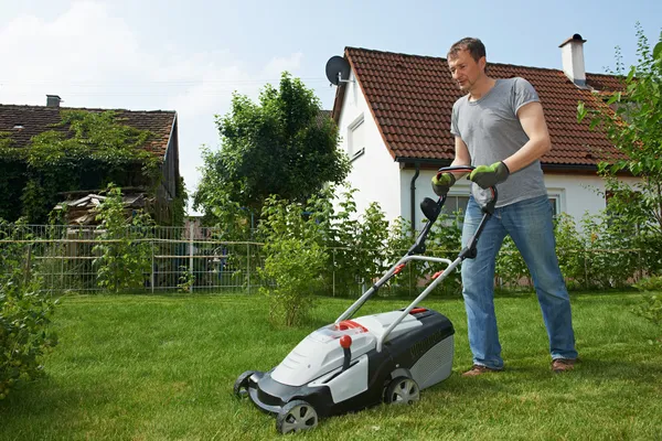 Man mowing lawn in backyard — Stock Photo, Image