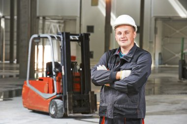 forklift önünde depo işçisi
