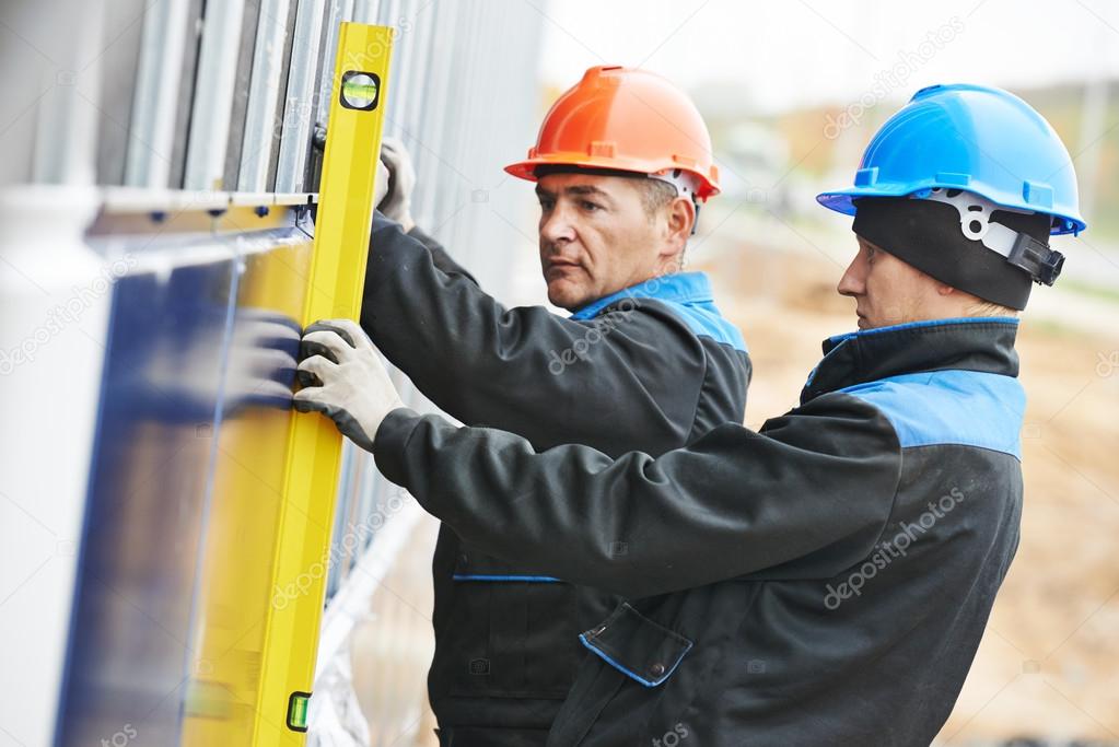 Builder facade plasterer worker with level