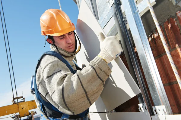 Constructor en la instalación de baldosas de fachada aireada —  Fotos de Stock