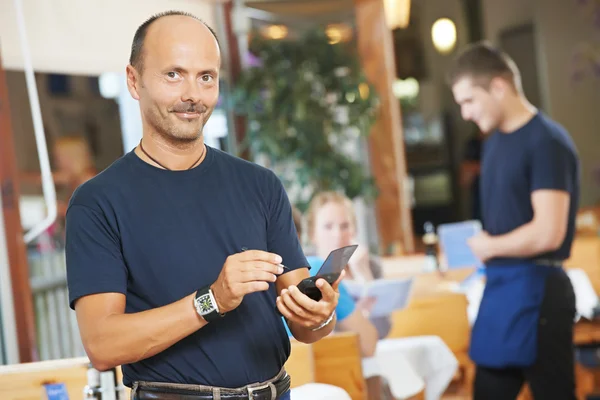 Kellner bedient junge Leute in Restaurant — Stockfoto