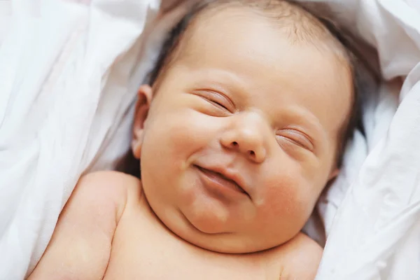 Smiling sleeping newborn baby — Stock Photo, Image