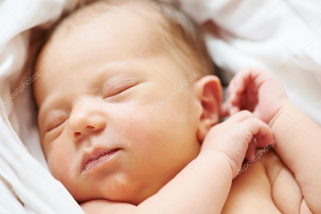Newborn baby in bedsheet