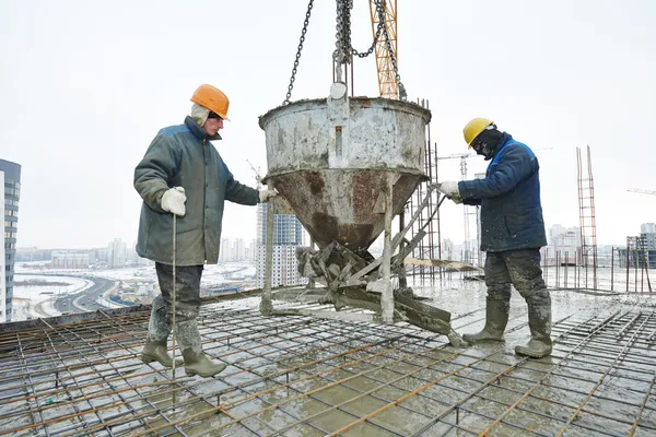 Construction workers pouring concrete in form Stock Photo