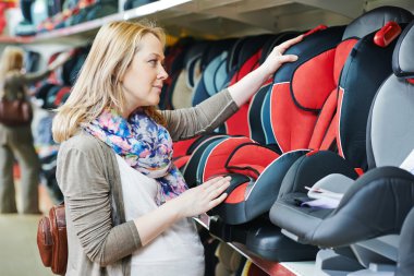 Woman choosing child car seat clipart