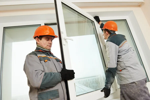 Dois trabalhadores instalando janela — Fotografia de Stock