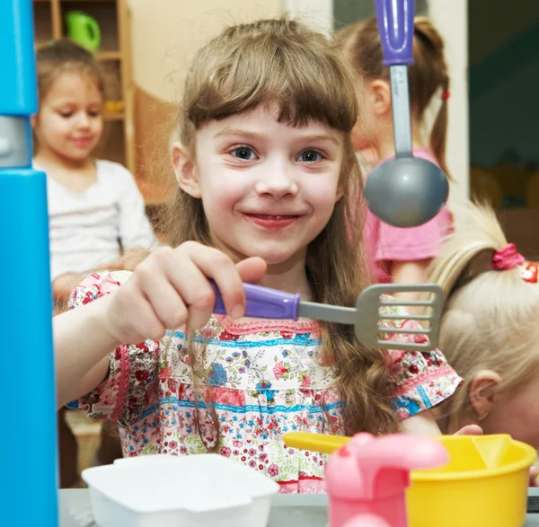 Menina jogando brinquedo cozinha — Fotografia de Stock