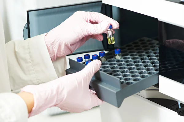 Hand i handske med kolven test på apoteket lab — Stockfoto
