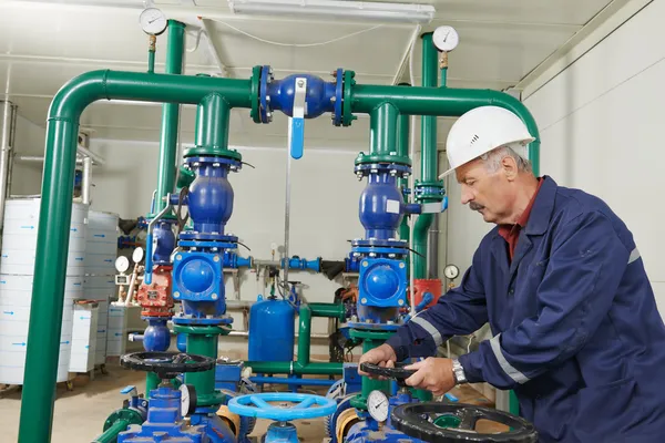 Tecnico di riscaldamento riparatore in locale caldaia — Foto Stock