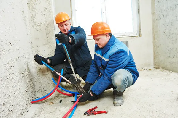 Reparadores de engenheiros instalam sistema de aquecimento — Fotografia de Stock