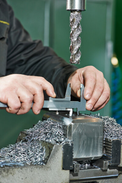 Worker measuring detail with caliper