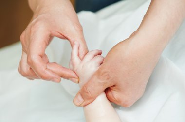 Masseur massaging a child hand clipart