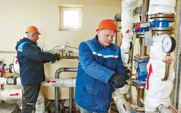 Tecnico di riscaldamento riparatore in locale caldaia — Foto Stock