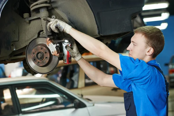 Mecánico automático en el reemplazo de zapatos de freno de coche — Foto de Stock