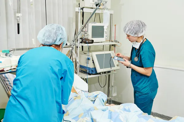 Chirurdzy kobiet w sali intensywnej terapii — Zdjęcie stockowe