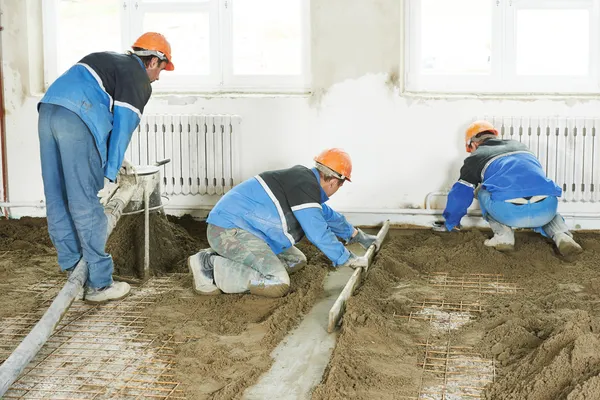 Estucador trabalhador concreto no trabalho no chão — Fotografia de Stock