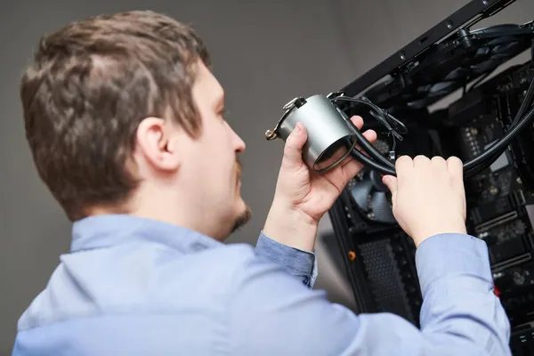 Servicio de ensamblaje de computadoras. Serviceman instalación de sistema de refrigeración líquida en el procesador —  Fotos de Stock