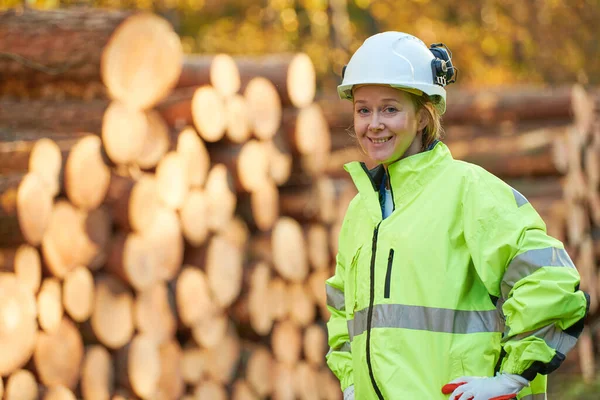 Trabajador forestal en ropa de trabajo protectora frente a un árbol de madera cortada —  Fotos de Stock