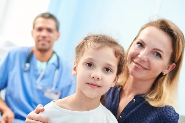 En el doctor. Madre sonriente con el niño - niña pequeña en la clínica — Foto de Stock