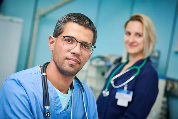 Portrait of surgeons team in hospital. Colored male and caucasian female doctors — Stock Photo, Image