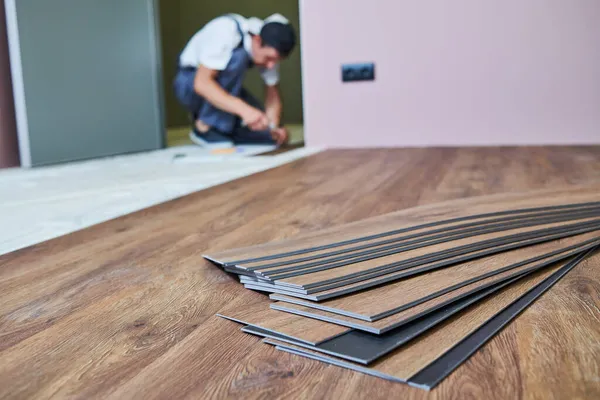 Vloeren. werknemer voegen vinyl vloerbedekking bij woningrenovatie — Stockfoto