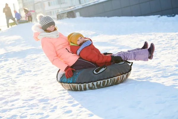 Crianças se divertindo equitação tubo de gelo slide no inverno — Fotografia de Stock