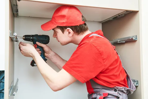 Meubelassemblage. Professionele werknemer installeren kast in woonkamer van nieuw huis. — Stockfoto