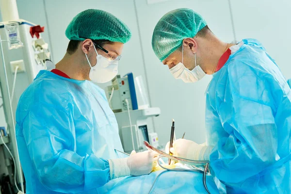 Cirurgia de emergência. Cirurgiões durante intervenção cirúrgica na clínica — Fotografia de Stock