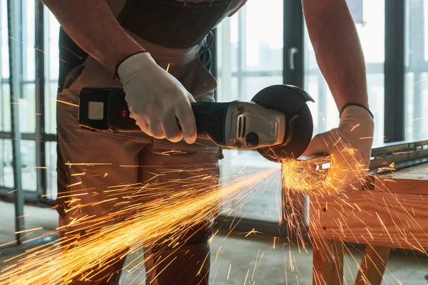 Lavori di costruzione. smerigliatrice angolare di uso del lavoratore per il taglio dei metalli con scintille — Foto Stock