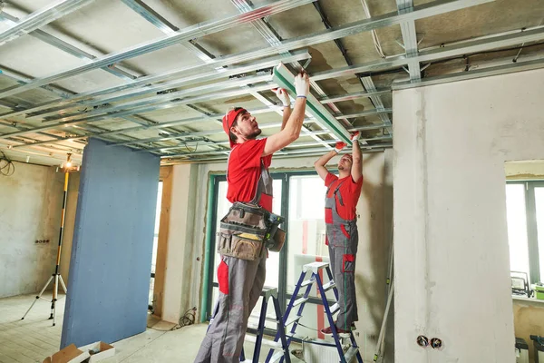 Gips gipsplaten. Drywall constructie thuis. Werknemer die metalen frame aan het plafond installeert — Stockfoto