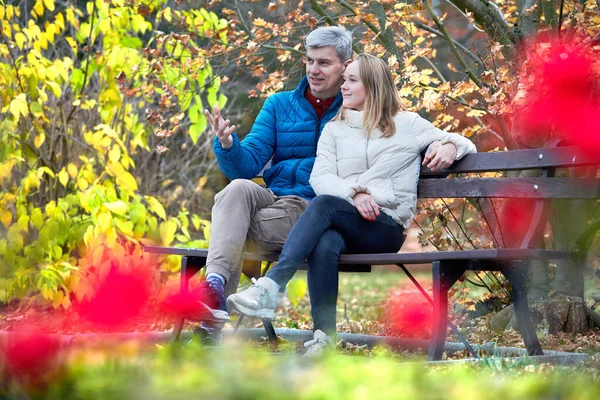 Młoda para dorosłych siedzi w parku i rozmawia — Zdjęcie stockowe