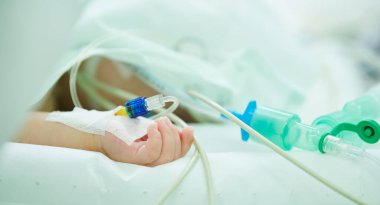 Çocuk ameliyatı. Hastanedeki cerrahi operasyonda damar içi serumla küçük bir el.