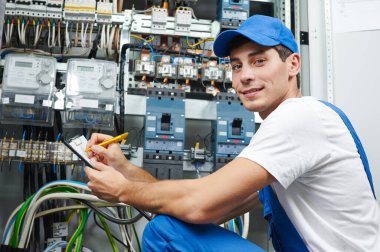 Elektrik işçisi ekipman ve elektrik sayacını denetliyor