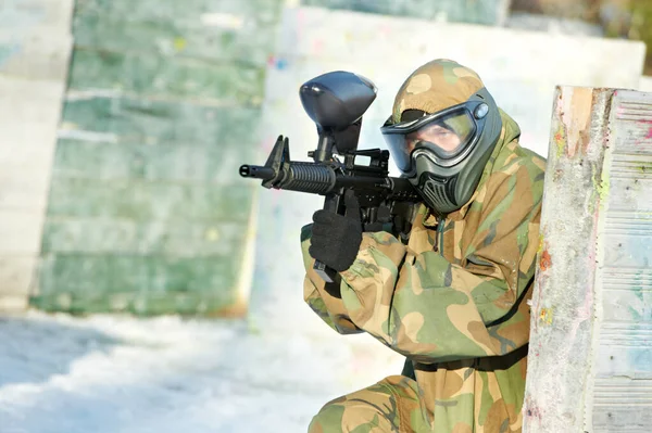 Paintball player with marker at winter outdoors — Stock Photo, Image