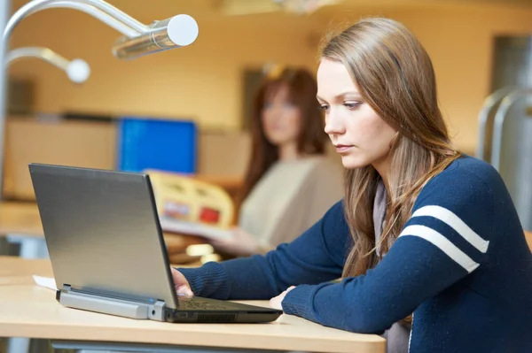 Jong student meisje werken met laptop in bibliotheek — Stockfoto