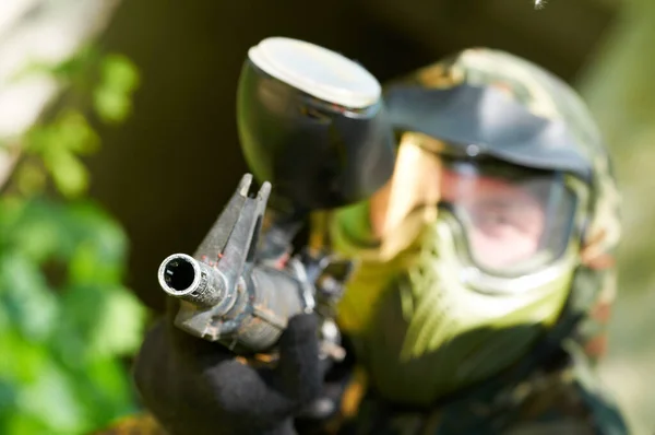 Paintball action game. player aiming and attacking from shelter — Stock Photo, Image
