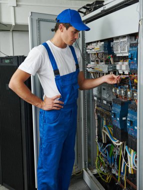 Elektrik mühendisi tamir için elektrik ekipmanlarını kontrol ediyor.