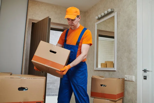 Servicio de mudanza o entrega. Trabajador de mudanzas que lleva cajas de cartón a casa —  Fotos de Stock
